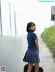 A woman in a school uniform is walking down the street.