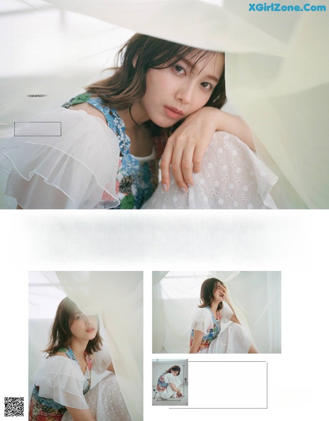 A woman in a white dress is posing for a magazine.
