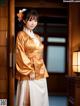 A woman in a kimono standing in front of a door.