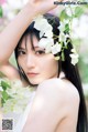 A woman with long black hair holding a bunch of white flowers.