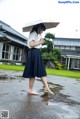 A woman walking in the rain holding an umbrella.