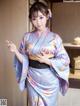 A woman in a blue and purple kimono posing for a picture.