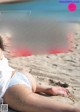 A woman laying on the sand on a beach.