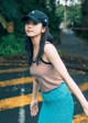 A woman in a striped tank top and a blue skirt.