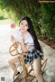 A woman sitting on a chair holding a watermelon.